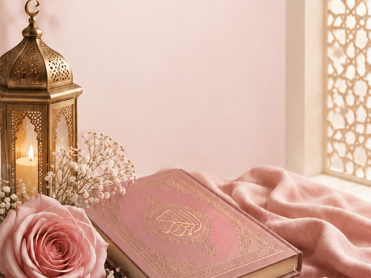 A Qur’an, a lit lantern and roses on a sunlit windowsill
